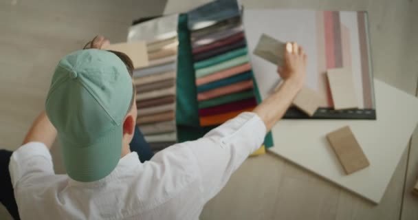 Profesiones creativas: el diseñador supera las muestras de tela y madera, compara el color y la sombra — Vídeos de Stock