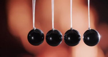 Newtons pendulum against the background of the fire. Energy transfer concept