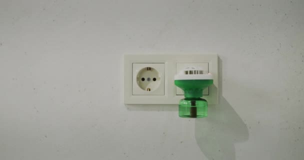 Fumigador eléctrico en una toma de corriente en la pared. Slider tiro — Vídeo de stock