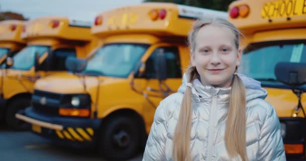 Portrait of a child against the background of a number of school buses — Video Stock