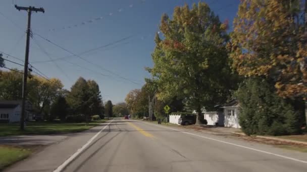 Drive through a small American town, view from the back window of the car to a typical street — Vídeo de stock