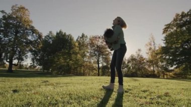 A happy mother plays with her two-year-old baby - presses him to her and circles him