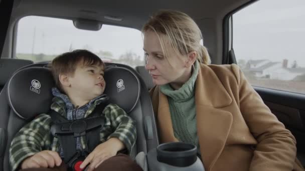 Madre e hijo conduciendo en el asiento trasero del coche — Vídeos de Stock