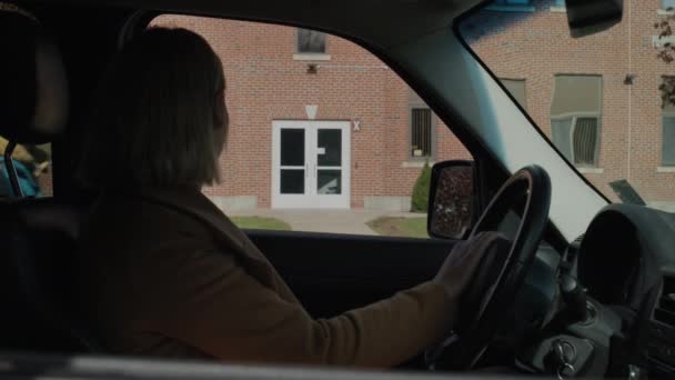 Una mujer trae a un niño a la escuela, una chica se baja de un coche y corre al edificio de una escuela típica estadounidense. — Vídeos de Stock