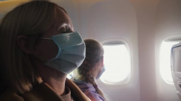 A kabinban repülés közben védőmaszkot viselő fáradt utasok — Stock videók