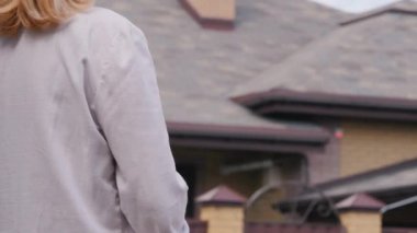 Postacı, kamyonetin evine bir paket getiriyor. Kadın da evin kapısından alıyor.