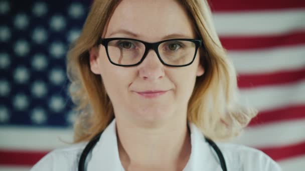 在美国国旗的背景下，一个戴面具的医生的脸 — 图库视频影像