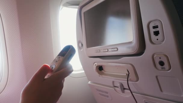 Дитина в захисній масці використовує розважальний дисплей на літаку — стокове відео