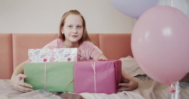 El niño se regocija en regalos de cumpleaños, abraza cajas con regalos — Vídeos de Stock