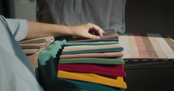 Eine Frau wählt Textilien für die Reparatur im Haus, vergleicht sie mit Tapetenbildern, wählt Farbe und Farbton — Stockvideo
