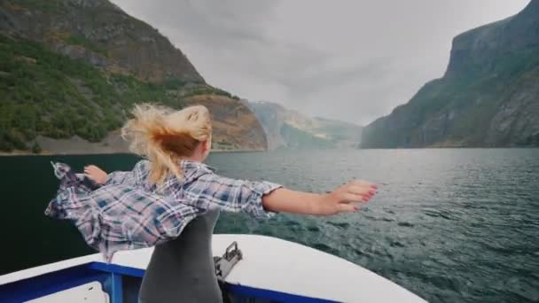 Känslomässig kvinna på fören av ett kryssningsfartyg jublar i mötande vind och en resa genom fjordarna — Stockvideo