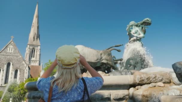 Visão traseira da mulher tirando fotos Gefion Fountain - uma fonte perto do porto em Copenhague. — Vídeo de Stock