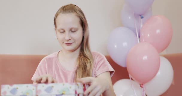 Ребенок открывает коробку с подарком на день рождения — стоковое видео