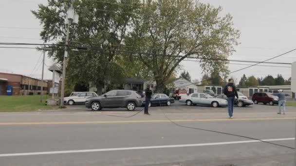 Clarence, NY, USA, October 2021: Автомобілі обминають перерву в кабелі живлення, волонтери регулюють трафік — стокове відео