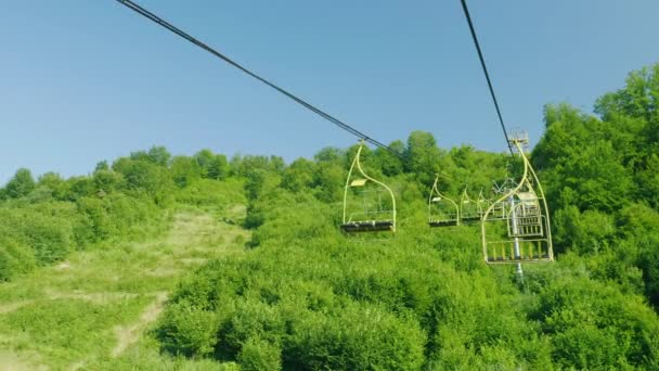 Καθίσματα από το λιφτ του σκι. Κινούνται προς τα πάνω φόντο του δάσους καλύπτεται με ένα δάσος. Διακοπές στα βουνά το καλοκαίρι — Αρχείο Βίντεο