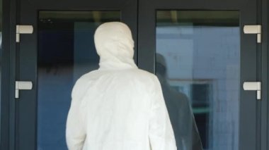 Man in a protective suit hands the doctor a red case with valuable medicines