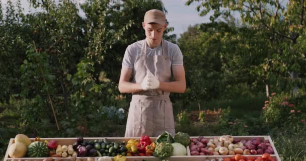 Een jonge boer aan zijn groenteteller — Stockvideo