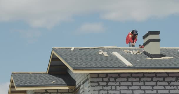 Construtor masculino que coloca telhas no telhado da casa — Vídeo de Stock