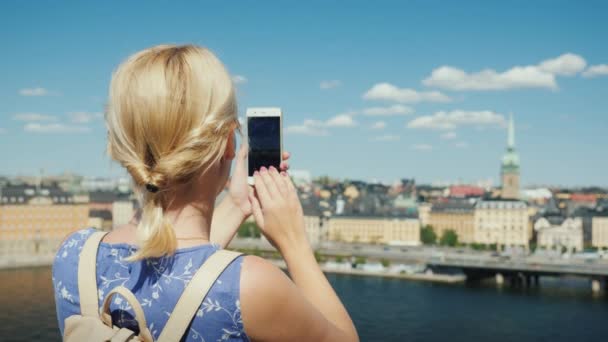 Une femme photographie une belle vue de la ville de Stockholm en Suède, vue arrière. Tourisme en Scandinavie concept — Video