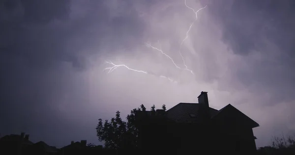 房子的轮廓后面闪烁着耀眼的闪电 晚上的风暴 — 图库照片