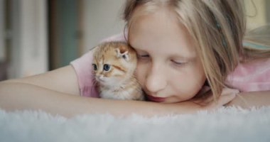 Bir çocuğun evcil hayvanıyla portresi, kızıl bir kedi yavrusu..
