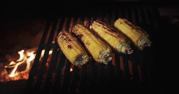 将美味的玉米芯放在烤架上 在热的煤块上煎 — 图库照片