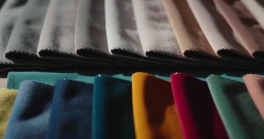 Mağazadaki tezgahın üzerinde çok renkli kumaş örnekleri var. Elbise dikmek için kumaş, mobilya döşemesi, perde ve diğer şeyler. Kaydırıcı atışı