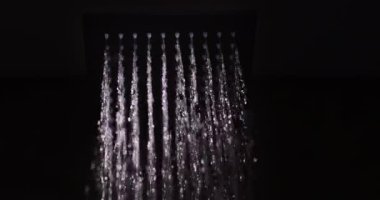 Kare duş başlığından su fışkırıyor. Elit tesisat ve konfor, yavaş çekim videosu.