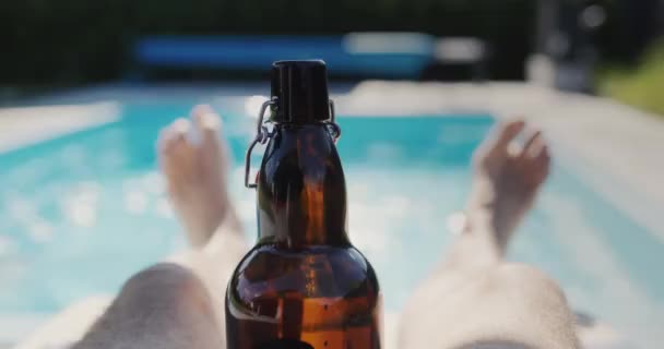 Чоловік Пляшкою Пива Розслабляється Біля Басейну Спекотний Літній День — стокове відео