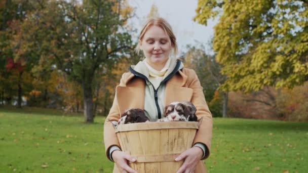 Middle Aged Woman Holding Basket Small Puppies Standing Park Autumn — Stock Video