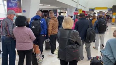 Passengers in masks at the airport terminal waiting to board their flight