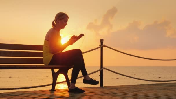 Fitness Woman Enjoys Tablet Sits Bench Pier Backdrop Rising Sun — Stock Video