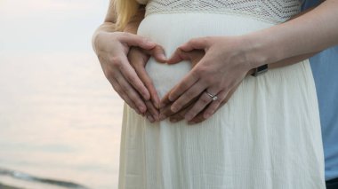 Adam hamile karısını göbek kucaklayan.