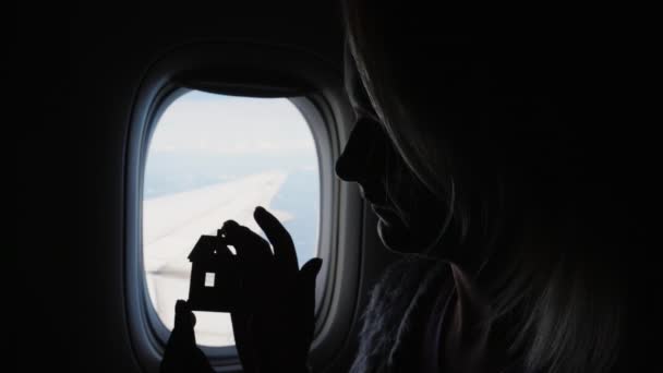Жінка Тримає Фігурку Будинку Руці Тлі Вікна Літаків Концепція Міс — стокове відео