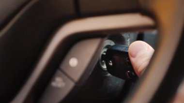 Kontak anahtarı kuyuya yerleştiriliyor ve araba motorunu çalıştırıyor. Yakın çekim.