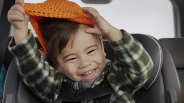 Szczęśliwy Azjatycki Dzieciak Jeździ Foteliku Dla Dziecka Bawi Się Pomarańczowym — Wideo stockowe