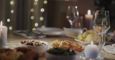 Bir kadın masaya şenlikli bir hindi koyar. Şükran Günü kutlaması.