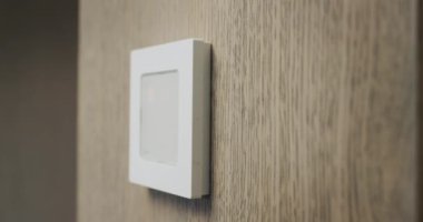 The homeowner regulates the temperature in the house on the electronic control panel.