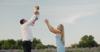 Happy young family playing with little daughter in lavender field. Slow motion 4k video