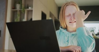 Bir kadın dizüstü bilgisayar ekranında ağlayan genç bir kızı sakinleştirir. Öğrenme kavramında sorunlar.