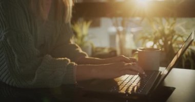 İş kadını sabahı. Dizüstü bilgisayarda yazı yazan eller, yakınlarda bir fincan sıcak çay..