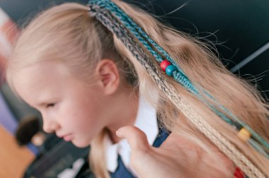 Doğal gözlüklü renkli örgüler, 5 yaşındaki sarışının iç mekânına yakın çekimde.