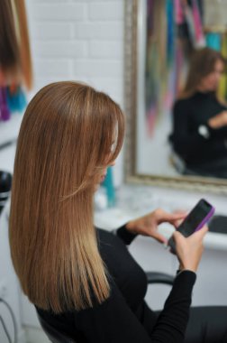 Güzeller güzeli, uzun kahverengi saçlı bir kadın güzellik salonunda.