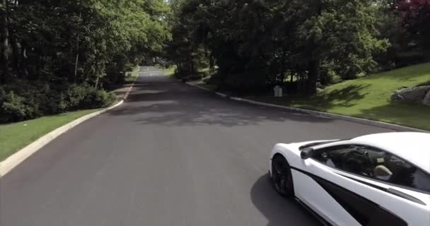 近所の白いマクラーレンスーパーカーの運転の航空 — ストック動画