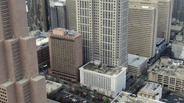 Atlanta, Georgia şehir merkezindeki hava perspektifinden gökdelenler ve tarihi mimarinin birleşimiyle karakterize edilen dinamik bir şehir manzarası sunuluyor. İkonik Peachtree Merkezi gökdelenleri bir sokak ağının ortasında dimdik duruyor.. 