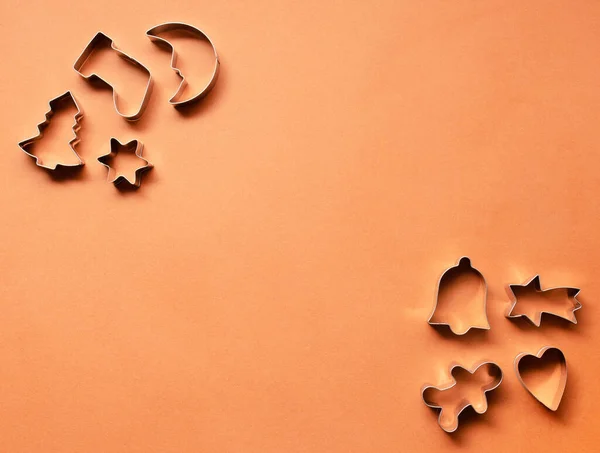 Ay şeklinde Noel pastası kalıpları, Noel ağacı, çorap, çan, kalp, kayan yıldız, tarçın rengi arka planda zencefilli ekmek adam. Asgari yeni yıl kavramı.