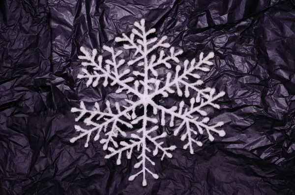 Neon renkli siyah bir arka planda kar tanesi. Yeni yıl yaratıcı kavramı.