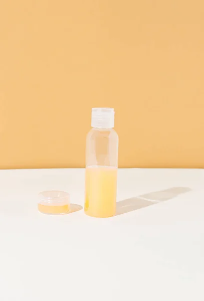 İçinde portakal suyu olan güzellik kozmetik cam şişesi. Damgalamak için uygun. Turuncu arkaplanda ön görünüm.
