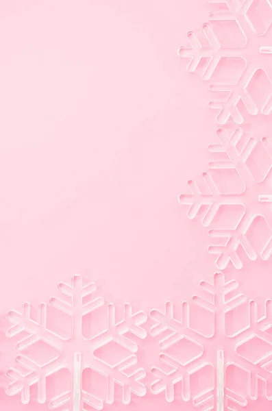 Yumuşak pembe arka planda beyaz şeffaf Noel kar taneleri. Kopya alanı ile Yeni Yıl kompozisyonu.