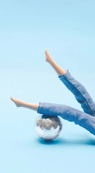 Kız ayaklarını disko topuna yasladı. Yaratıcı tatil konsepti. Minimum Yeni Yıl Sahnesi.